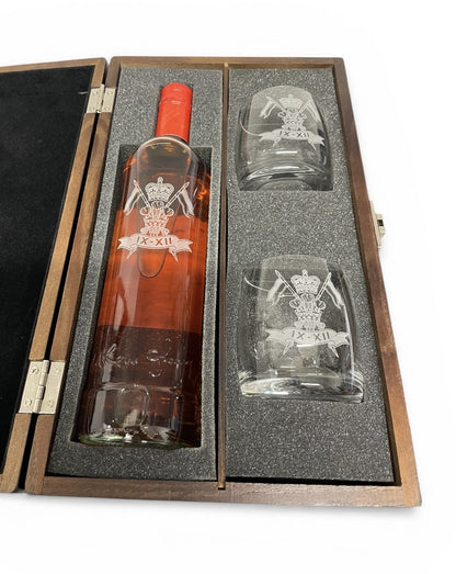 Bottle of whisky and two glasses in a wooden case with engraved design.