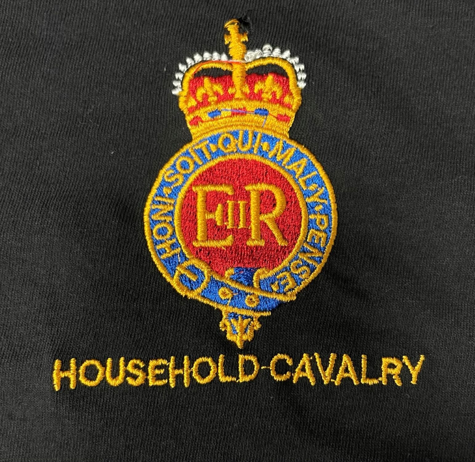 Household Cavalry embroidered crest on a black fabric background, featuring a crown above a red, gold, and blue circular emblem with the letters E.R.